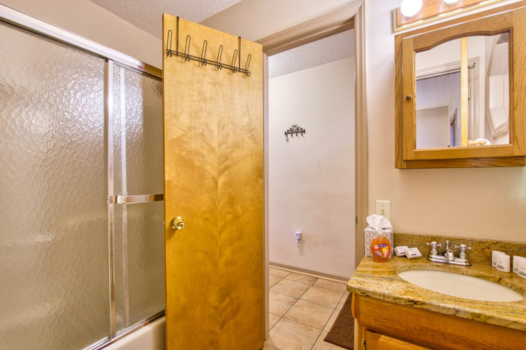 The hall bath at Crawdad Corner has a tub/shower combo and single sink vanity.