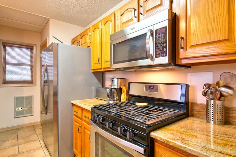The kitchen offers granite counters, stainless steel appliances including a gas range, and plenty of cabinet space.