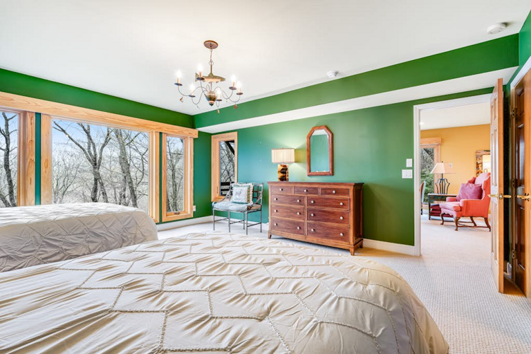 Large windows fill this guest room with natural light and peaceful forest scenery.