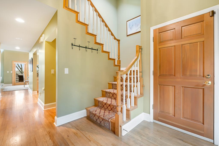 An open staircase and warm hardwood floors connect the home's spacious living areas.