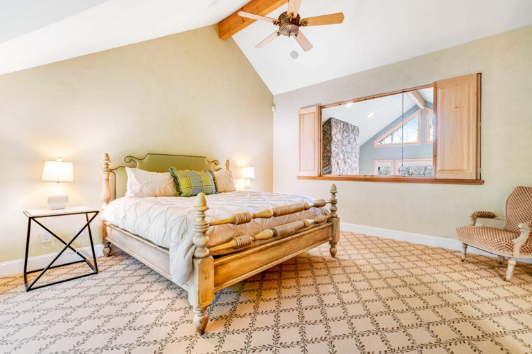Retreat to a spacious primary bedroom with King bed, vaulted ceilings and a warm, restful atmosphere.