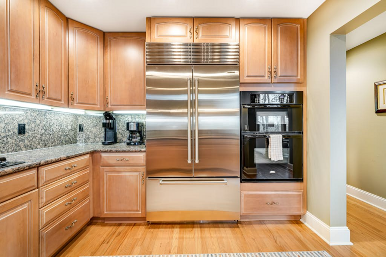 Stainless steel appliances and warm wood cabinetry complete the inviting kitchen.