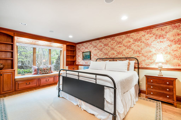 Wake up to peaceful wooded views from this spacious, inviting bedroom.