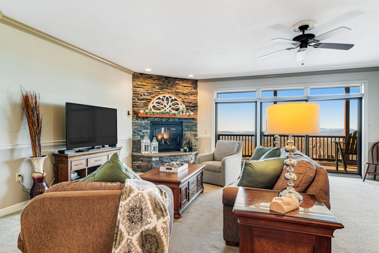 Comfortable seating, a stone fireplace, and mountain views make the living room an inviting place to gather.