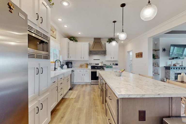 Generous counter space and a large island make this bright kitchen a natural gathering spot.