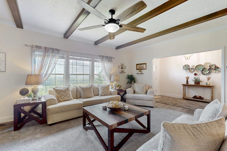 Large windows fill the living room with natural light and bring the peaceful mountain setting indoors.