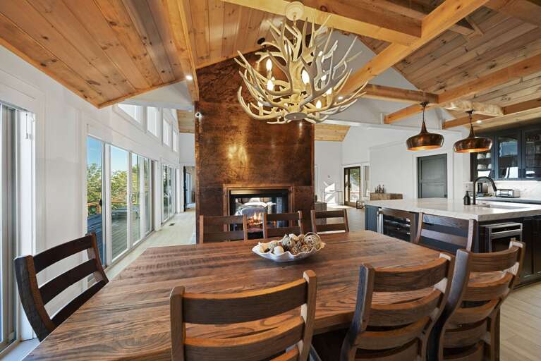 Dining for 8 near towering double sided fireplace