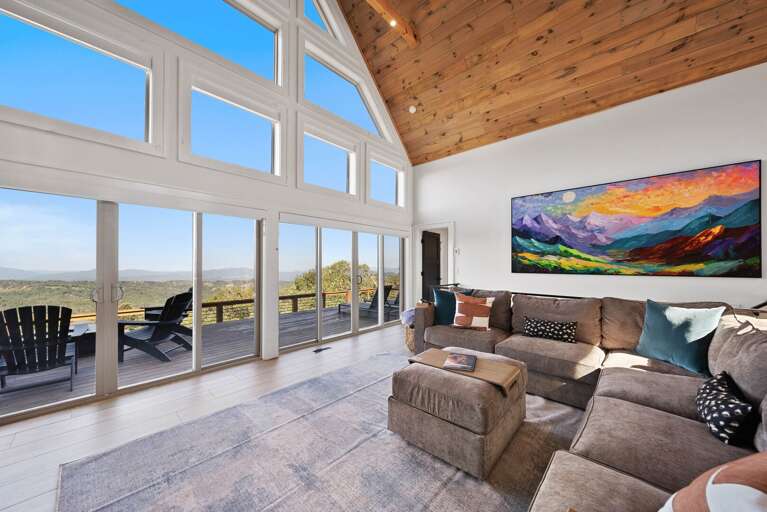 Great room with floor to ceiling windows and deck access