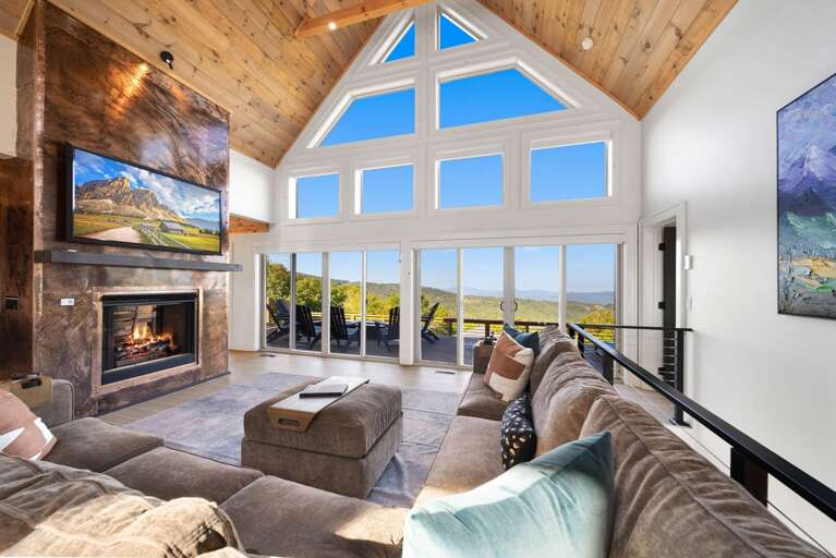 Great room with floor to ceiling windows and deck access