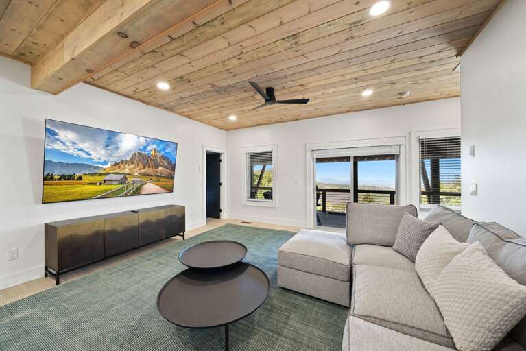 Lower Level 1 Family Room with deck access, mounted TV and large sectional