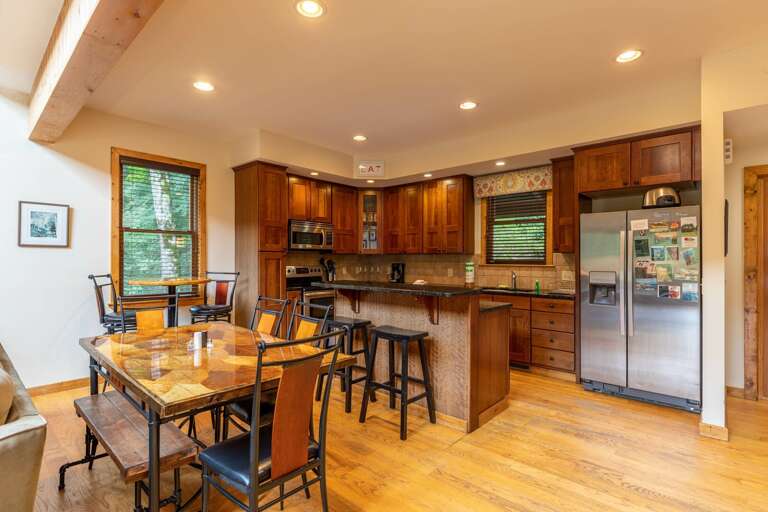 Residential Kitchen Interior With Wooden Cabinets And Dining Area Residential Kitchen Interior With Wooden Cabinets And Dining Area