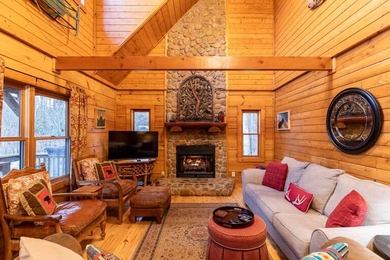 Rustic Room With Vaulted Ceiling, Stone Fireplace, And Wooden Beams