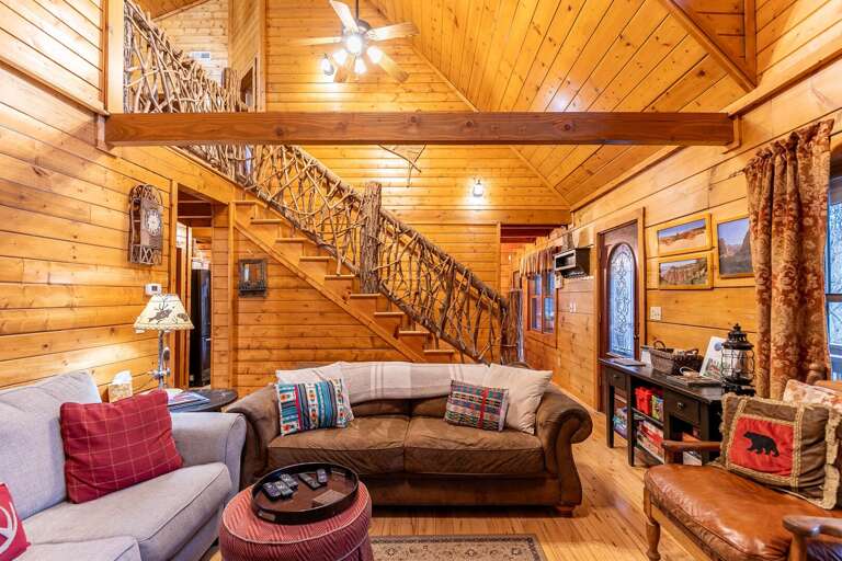Wood-lined Living Space With Stairs, Sofa, And Rustic Decor
