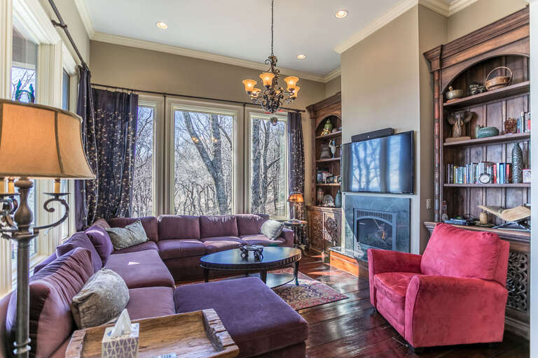 On the other side of the kitchen is a den with a couch, gas log fireplace, and a 60” HDTV, perfect for those wishing to be near the kitchen action while not missing a favorite show.