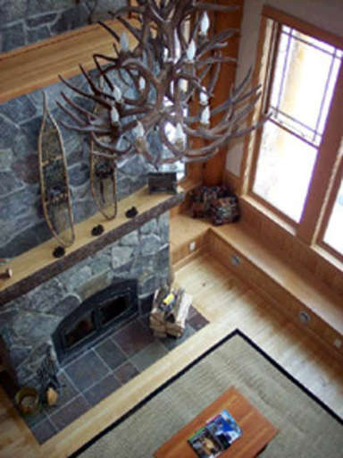 Great room with granite fireplace and wall of windows overlo