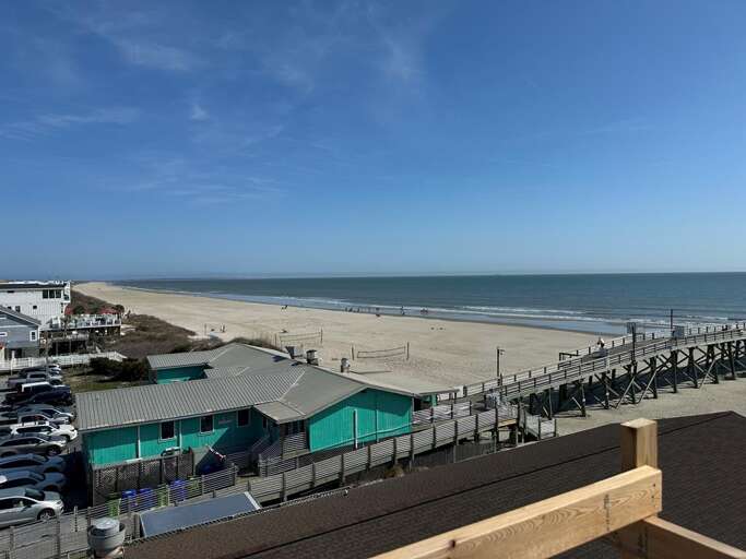 Beachfront View With Sandy Shore And Blue Sky