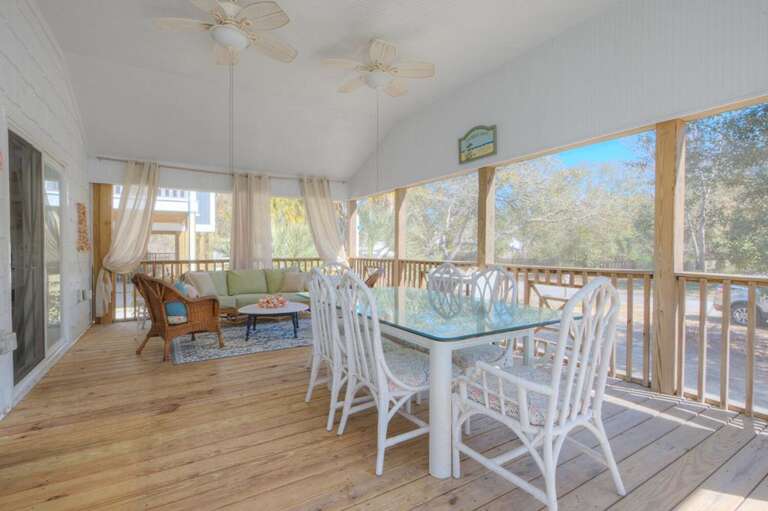 Screened Porch With Wicker Chairs, Glass Table, And Wooden Floor