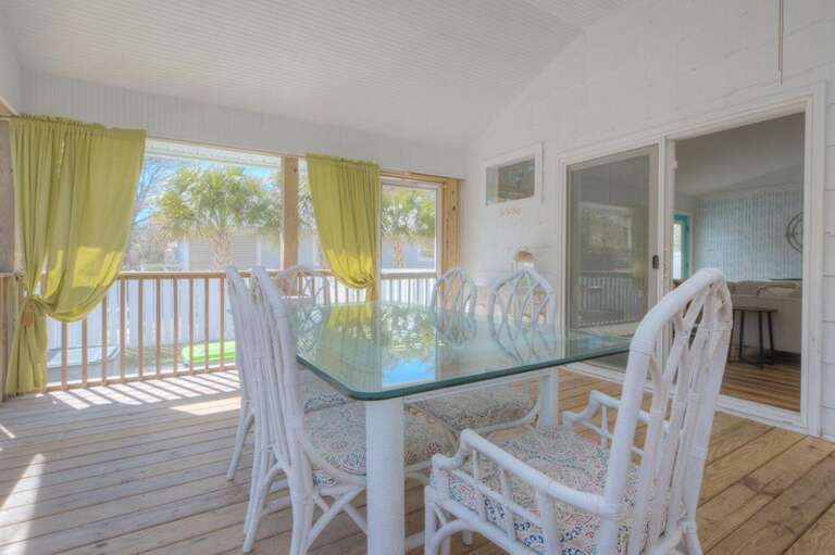 Sunlit Space With Wicker Chairs And Glass Table