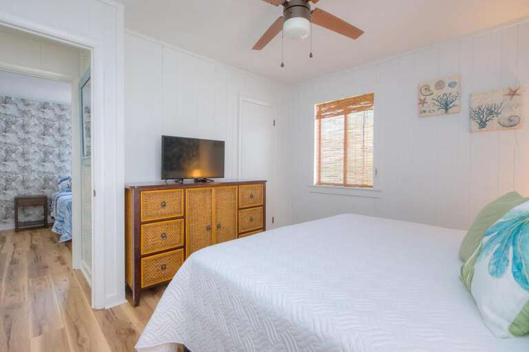 Bedroom With Bed, Dresser, TV, Ceiling Fan, Window, Ocean-themed Decor