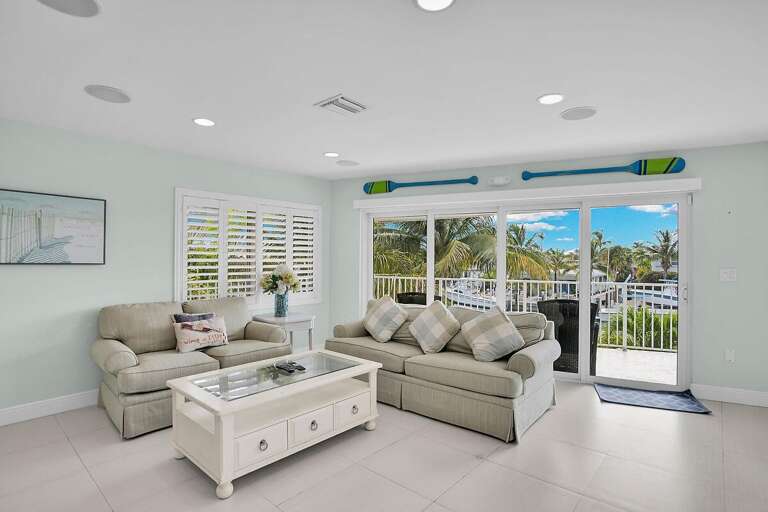 Bright Living Room With Beige Sofas And Open Balcony Door
