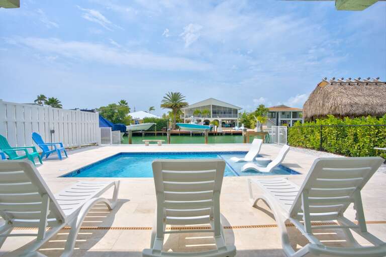 Outdoor Pool Area With Sun Loungers And A Thatched Pavilion Outdoor Pool Area With Sun Loungers And A Thatched Pavilion