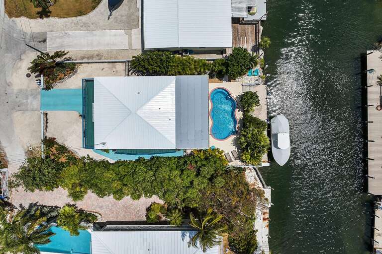 Aerial View Of Waterfront Property With Pool And Docked Boat Aerial View Of Waterfront Property With Pool And Docked Boat