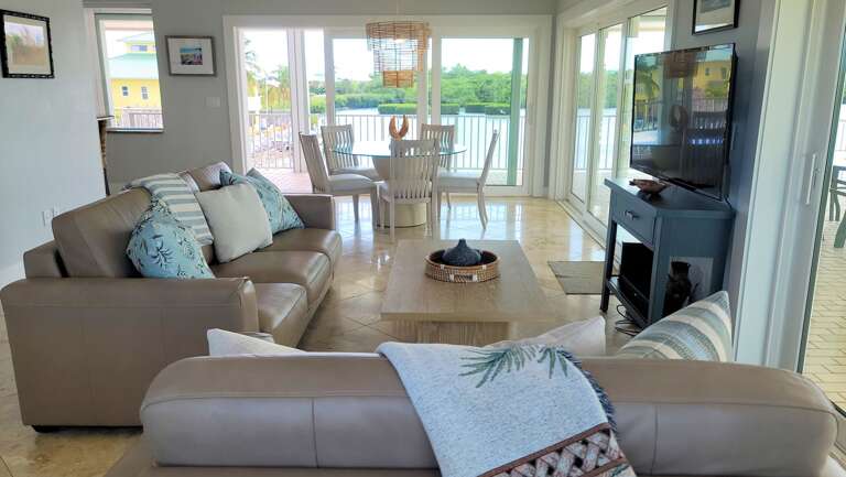 Living Room Interior With Sofas, Table, And Waterfront View