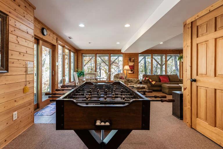 Wood-paneled Room With Foosball Table And Forest View