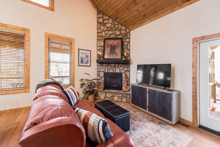 Lounge With Leather Sofa, Stone Fireplace, And Wooden Beams