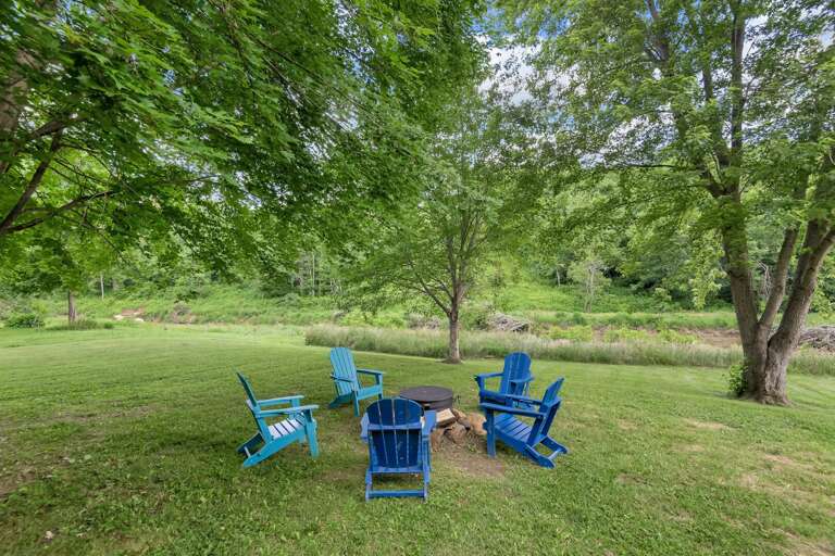 Blue Chairs By Green Grass Near Gentle Stream