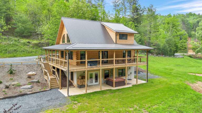 Wooden Structure Surrounded By Green, Gracefully Perched In Pastoral Setting