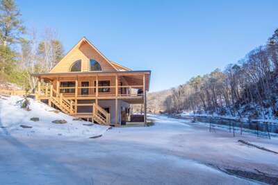 Wooden Winter Retreat Near Frozen Lake Surrounded By Snow-dusted Trees