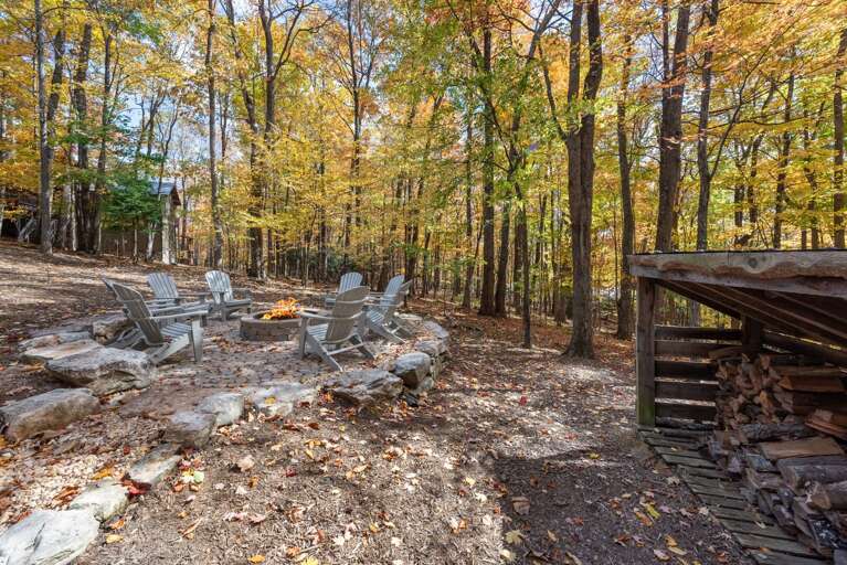 Leafy Retreat With Chairs Facing Fire Pit, Nestled In Vibrant Forest