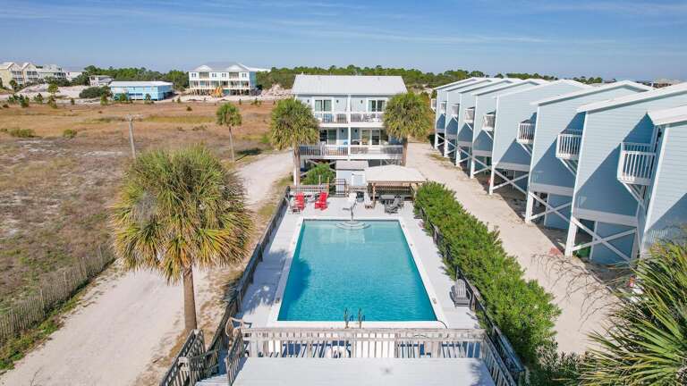 Aerial View Of A Beachside Vacation Rental Complex With Swimming Pool
