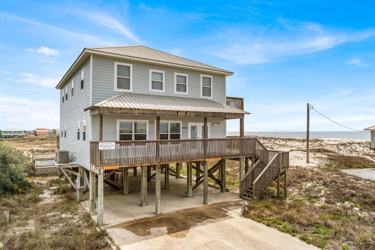 Beachside Building Perched On Stilts By Sandy Shore