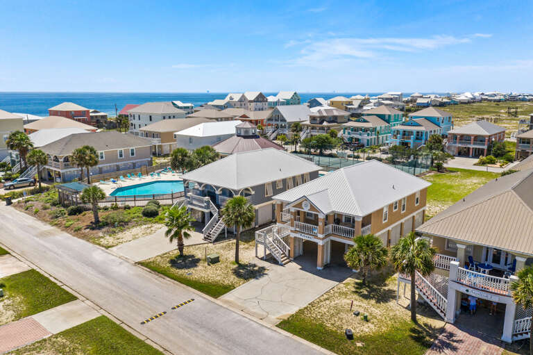 Aerial View Of A Coastal Community With Clustered Homes And A Pool