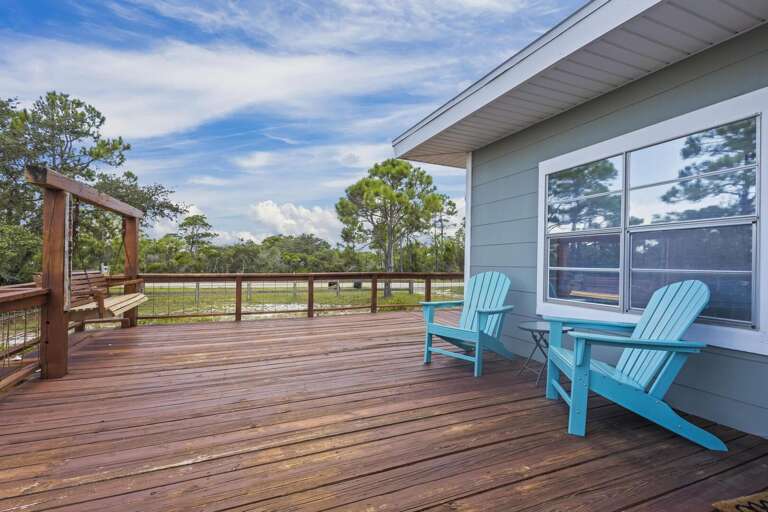 Blue Chairs Balancing On A Broad Boardwalk Beneath A Big Blue Sky