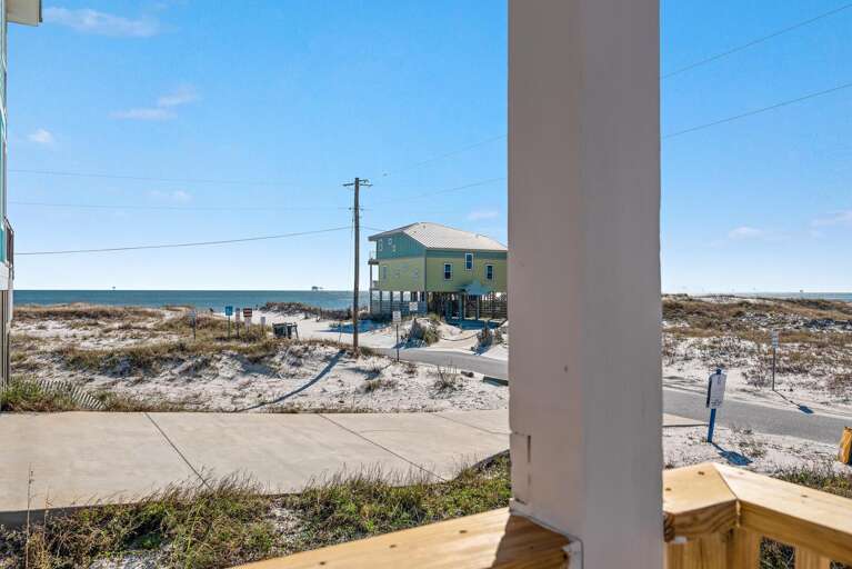 View Of Beachfront Buildings, Sandy Shore, And Serene Sea From A Balcony