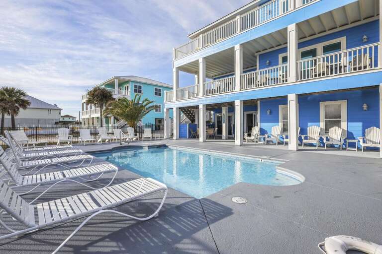Blue Buildings Bordering A Bright Pool, Loungers Lined Leisurely
