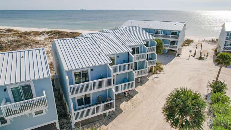 Seaside Structures Shining Under Sun, Surrounded By Sand And Sea