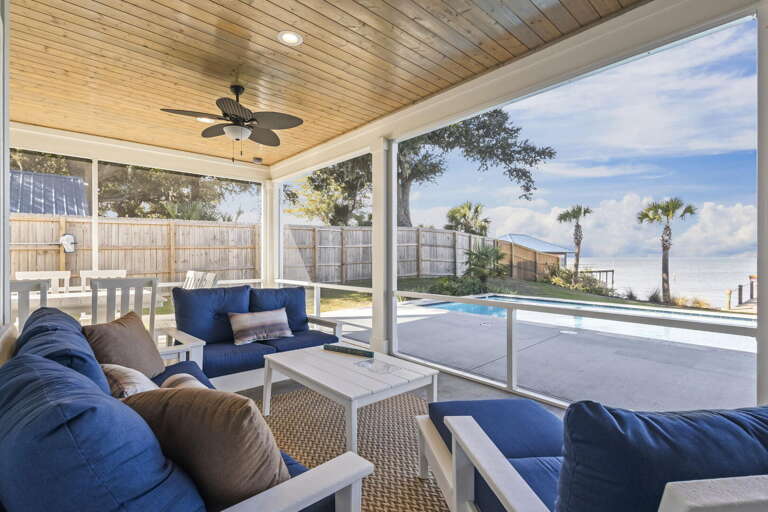 Blue Seating Beside Pool Under Covered Patio With Ceiling Fan