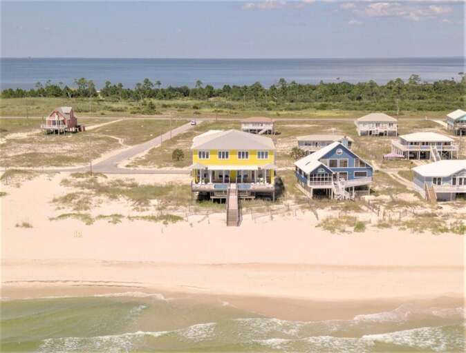 Aerial View Of Coastal Cabins Beside Beach, Blue-roofed Abode Beside Beige Sands