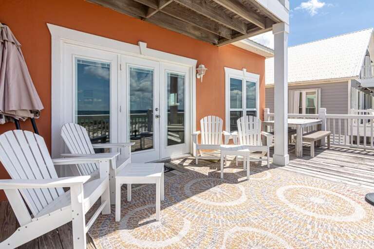 Balcony Beach View With White Chairs And Glass Doors