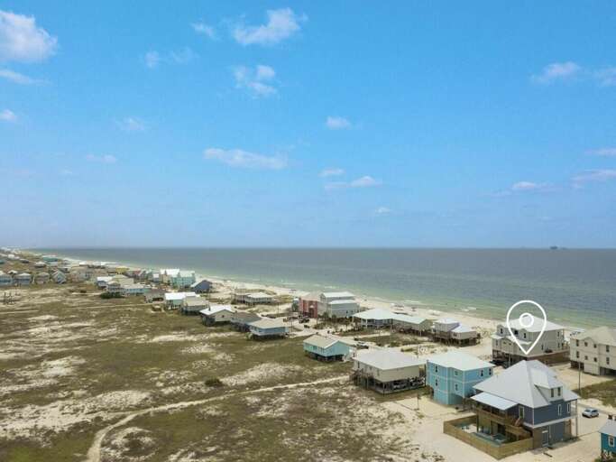 Aerial View Of Homes Beside Beach, Blue Skies Above
