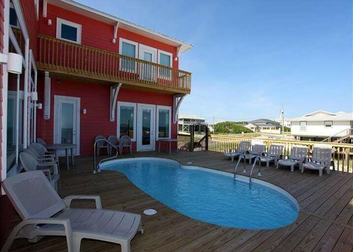Red Residence With Poolside Patio, Plastic Chairs, Beneath Blue Sky