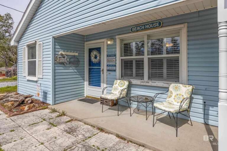 Blue Beach House With Two Chairs On Porch