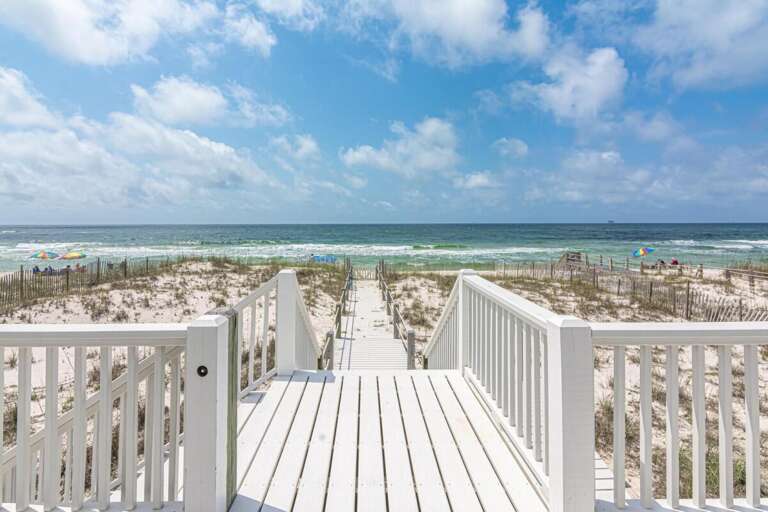 White Walkway Winding Toward Water, Past Pristine Dunes