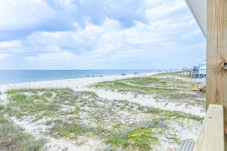 Seaside Scenery Showing Sandy Shore And Serene Sky, Viewed From Wooden Walkway