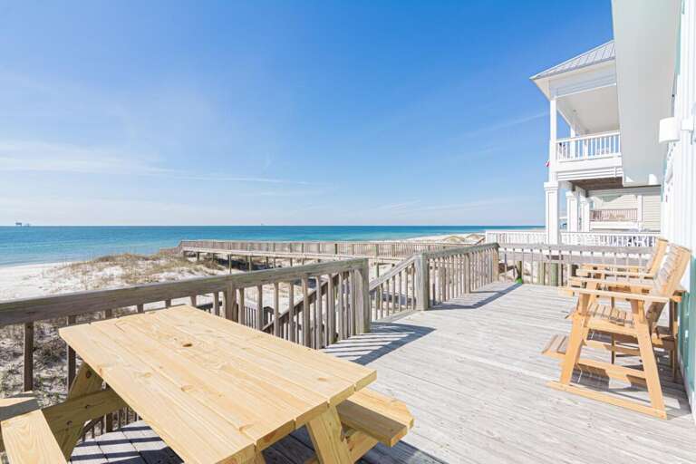 Seaside Structure Showing Sunlit Deck, Distant Ocean, And Blue Sky