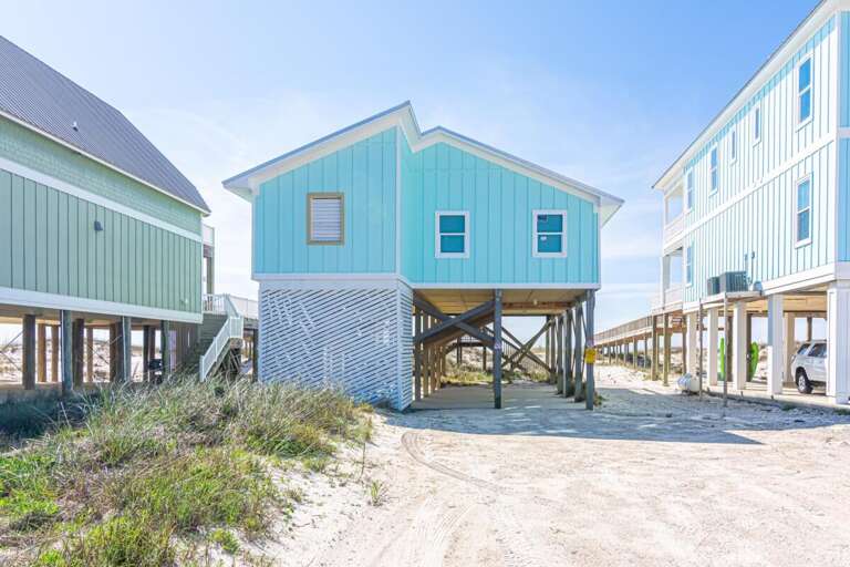 Blue Beachside Building Between Beige Homes